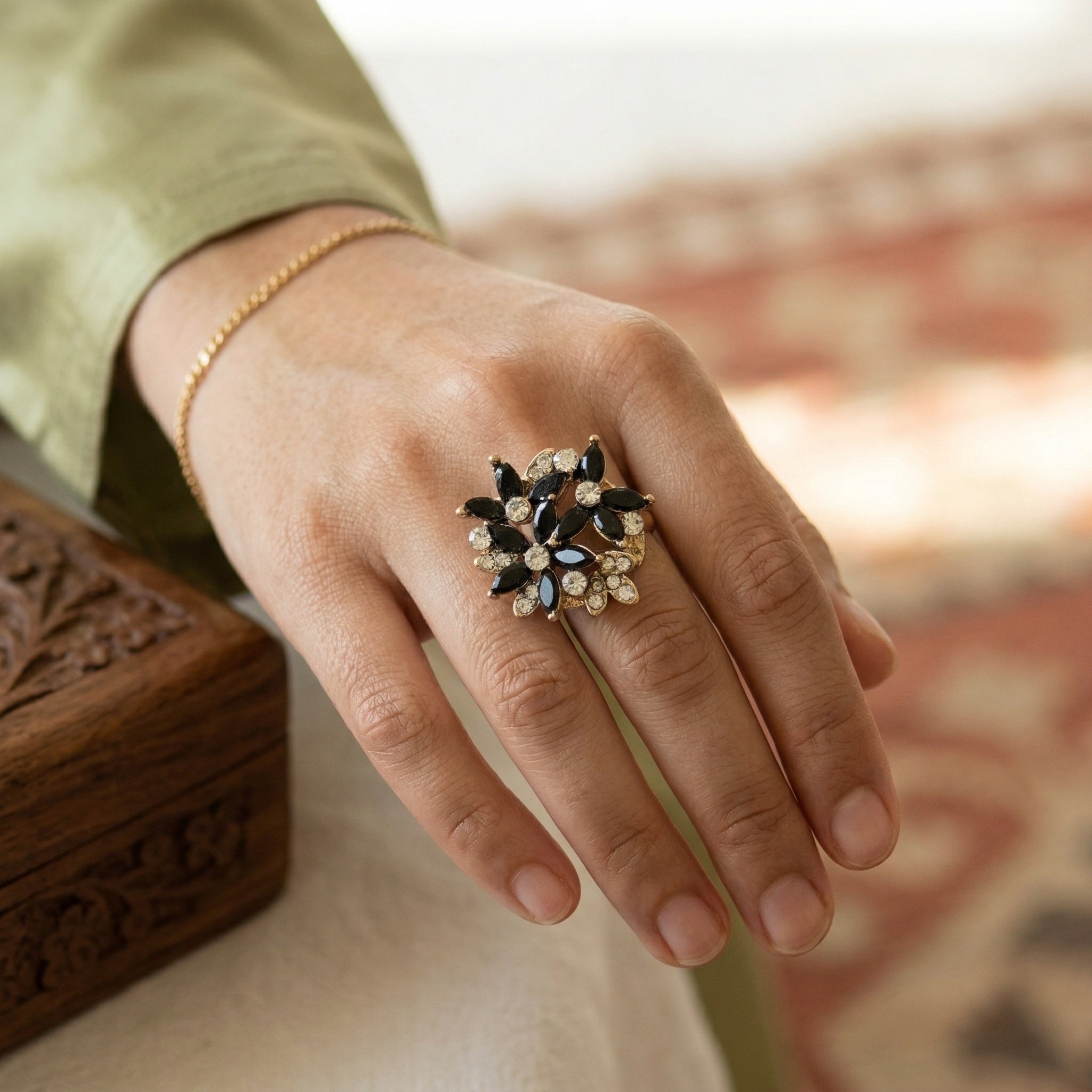 Hand wearing a ring with a blurred background