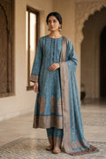 Woman wearing a traditional blue and brown outfit in an ornate indoor setting