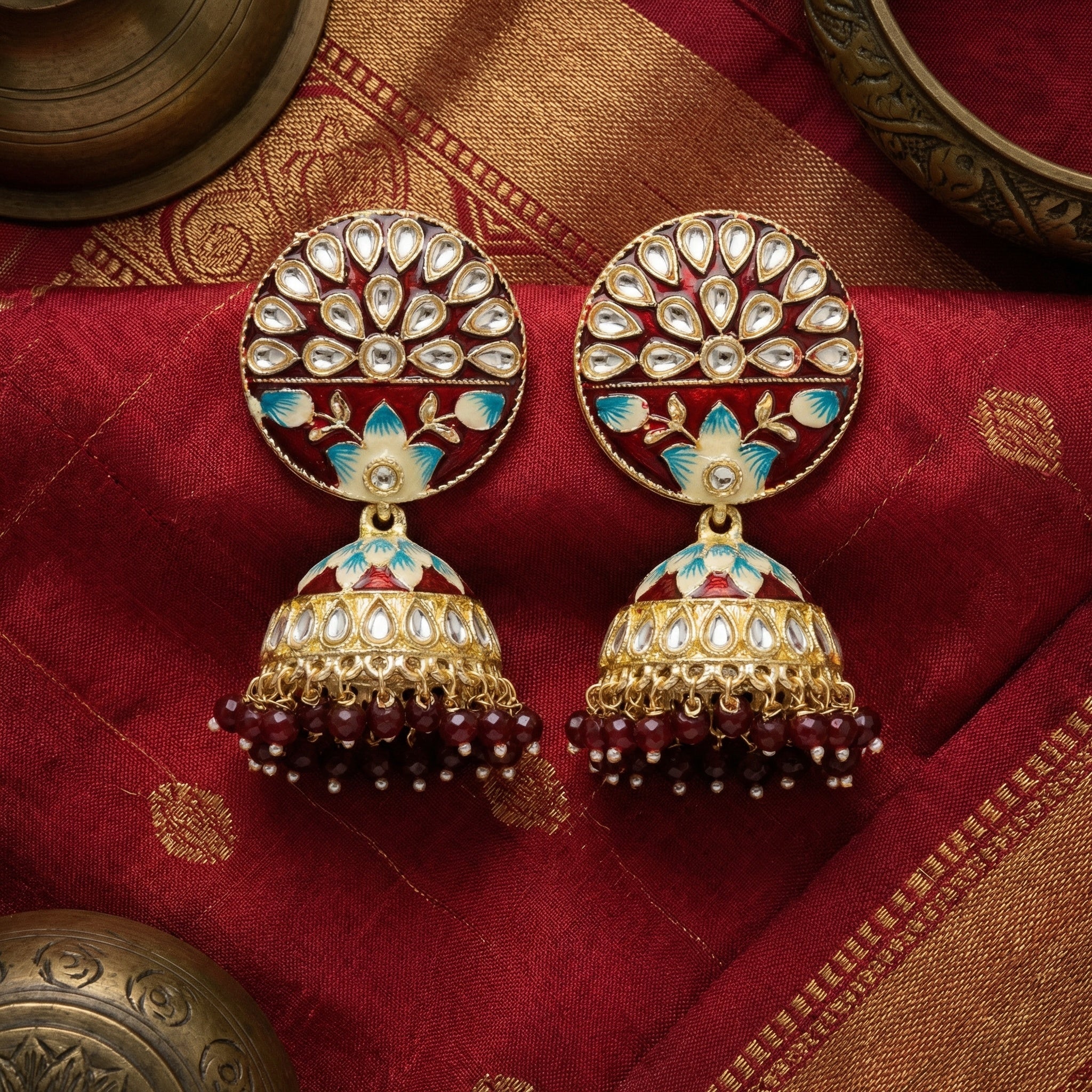 Ornate earrings on a red fabric background